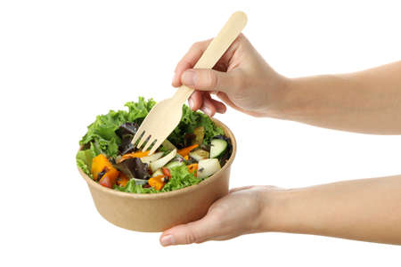 Female hands holding plate of pumpkin salad and fork, isolated on white backgroundの写真素材