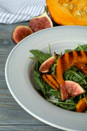 Concept of tasty eating with pumpkin salad on wooden background