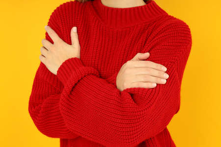 Girl in red sweater on yellow background, close up.の写真素材