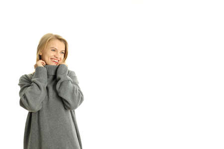 Attractive girl in sweater isolated on white background, space for text.の写真素材
