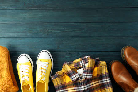 Shirt, sweater, sneakers and boots on wooden table.の写真素材