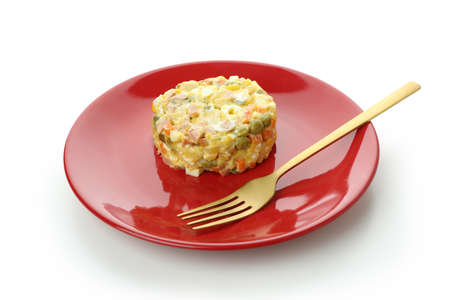 Plate with Olivier salad and fork isolated on white backgroundの写真素材