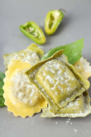 Raw ravioli with spices on light gray backgroundの写真素材