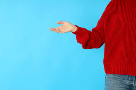 Girl in red sweater and jeans on blue background, close up.の写真素材