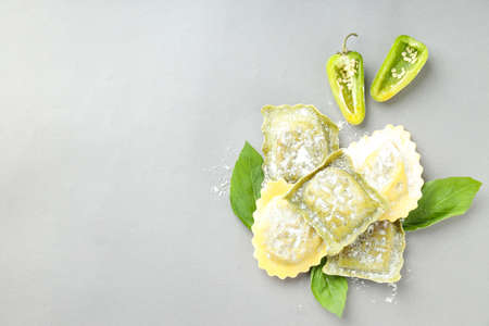 Raw ravioli with spices on light gray backgroundの写真素材