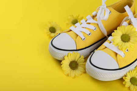 Yellow sneakers with flowers on yellow backgroundの写真素材