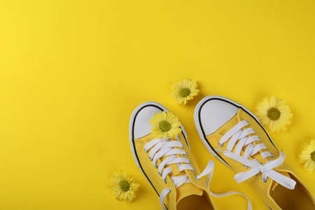 Yellow sneakers with flowers on yellow backgroundの写真素材