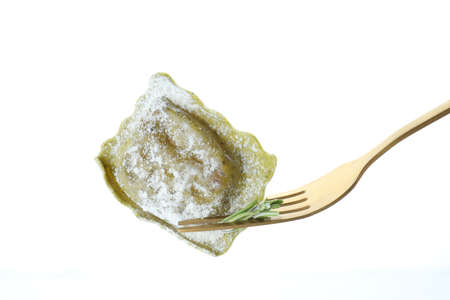 Fork with raw ravioli isolated on white background
