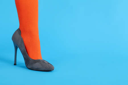 Female leg in orange sock and in heels on blue backgroundの写真素材