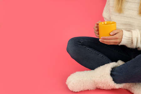 Attractive girl with cup of hot drink on pink background.の写真素材