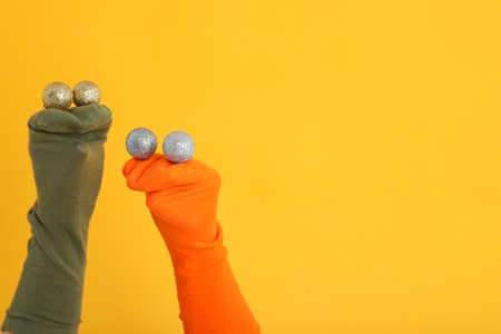 Sock puppets with baubles on yellow backgroundの写真素材