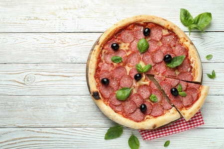 Concept of tasty food with Salami pizza on white wooden backgroundの写真素材