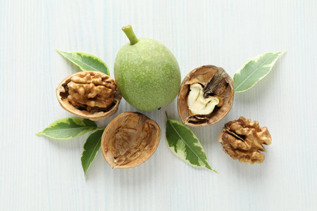 Walnuts with nut peel on white wooden backgroundの写真素材