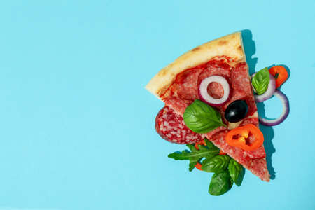 Slice of Salami pizza on blue backgroundの写真素材