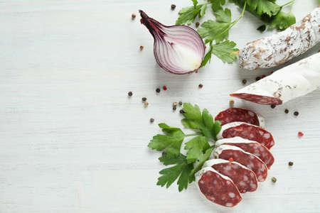 Ð¡oncept of tasty food with salami sausage on white wooden backgroundの写真素材