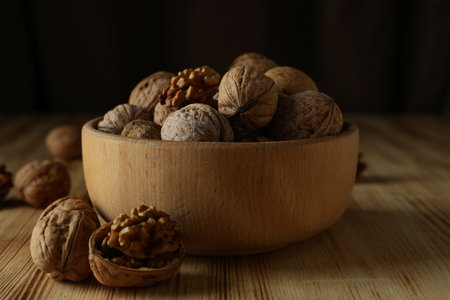 Walnuts in wooden bowl on wooden tableの写真素材