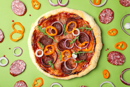 Concept of tasty food with Salami pizza on green backgroundの写真素材