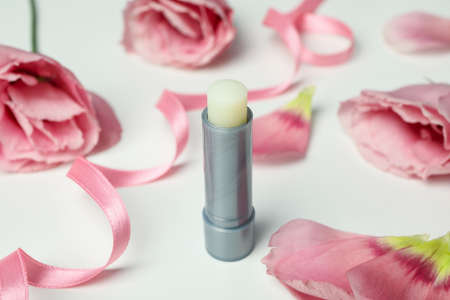 Hygienic lipstick and roses on white backgroundの写真素材