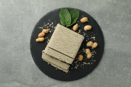 Concept of tasty food with halva on gray textured background