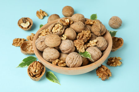 Walnuts in wooden bowl on blue backgroundの写真素材