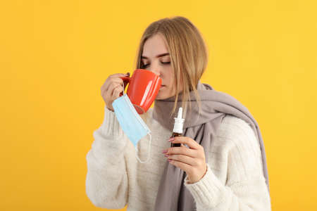 Ill young woman on yellow background, seasonal cold conceptの写真素材