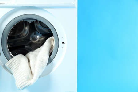Concept of housework with washing machine on blue background