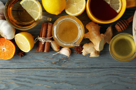 Concept of treatment colds with honey and garlic on gray wooden background