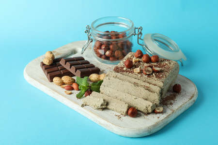 Concept of tasty food with halva on blue background
