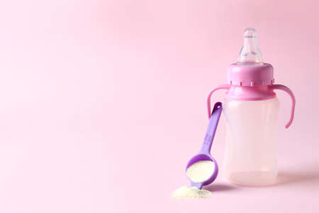 Concept of baby food with powdered milk on pink background