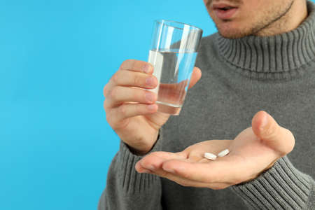 Young man is taking pills, seasonal cold conceptの写真素材