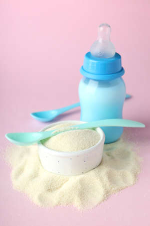 Concept of baby food with powdered milk on pink backgroundの写真素材