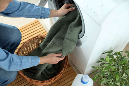Concept of housework with washing machine and girl on white background