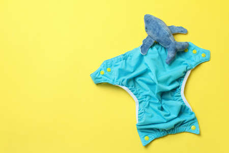 Concept of baby clothes with reusable diapers on yellow backgroundの写真素材