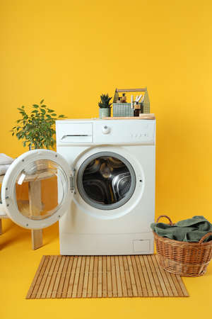 Concept of housework with washing machine on yellow backgroundの写真素材