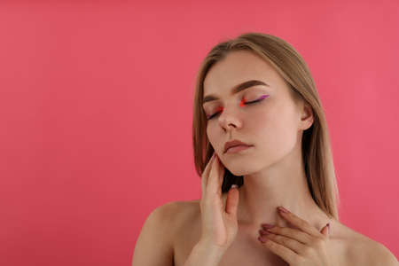 Beautiful model girl with makeup on pink backgroundの写真素材