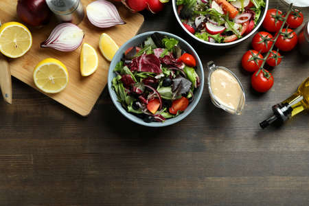 Concept of tasty food with vegetable salad with tahini sauce on wooden backgroundの写真素材