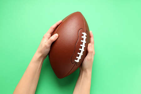 American football ball on mint background, space for textの写真素材