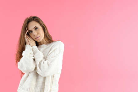 Attractive woman in sweater on pink backgroundの写真素材