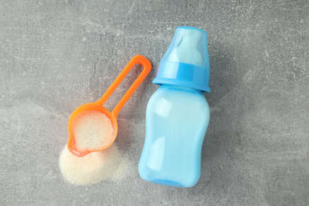 Concept of baby food with powdered milk on gray textured backgroundの写真素材