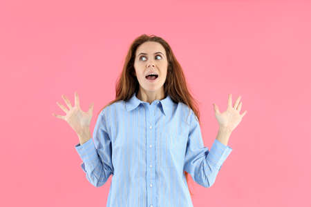 Attractive woman in t-shirt on pink background