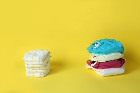 Concept of baby clothes with reusable diapers on yellow backgroundの写真素材