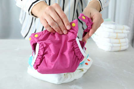 Concept of baby clothes with reusable diapers on light textured tableの写真素材