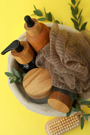 Concept of gift with basket of cosmetics on yellow backgroundの写真素材