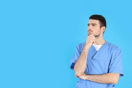 Young attractive male nurse on blue backgroundの写真素材