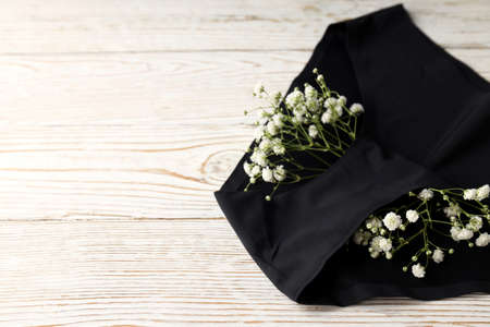 Concept of women's clothes with panties on white wooden background