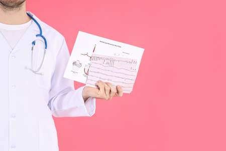 Doctor - intern with cardiogram on pink backgroundの写真素材
