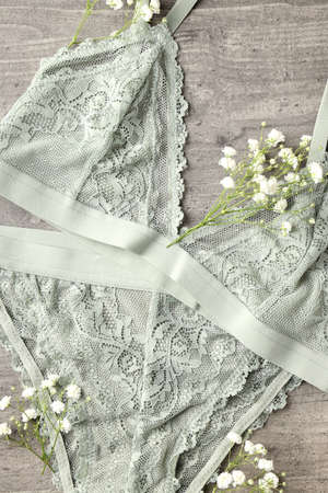 Concept of women's clothes with underwear on gray textured background