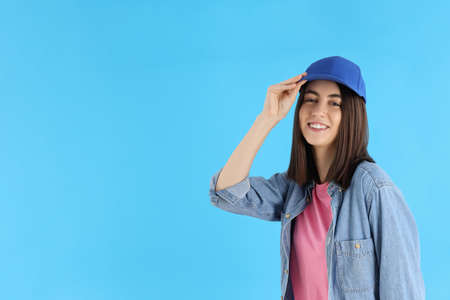 Attractive girl in cap on blue background