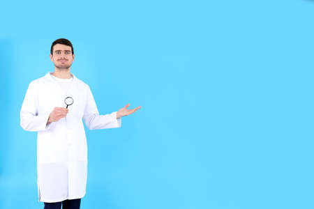 Doctor - intern with magnifier on blue backgroundの写真素材