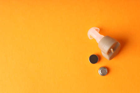 Concept of health care with hearing aid on orange backgroundの写真素材